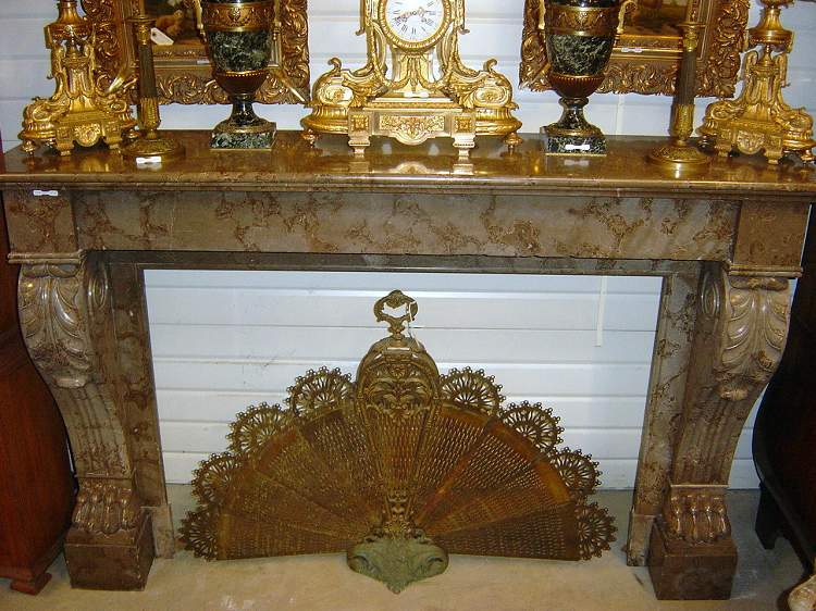 A brownish marble Regence style fire mantle
