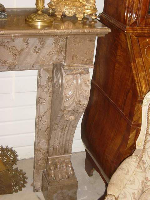 A brownish marble Regence style fire mantle