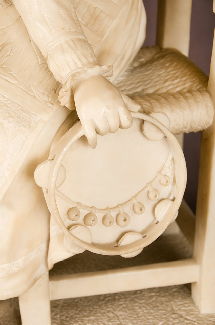 Alabaster sculpture of a seated girl with tambourine in traditional costume France 19th Century