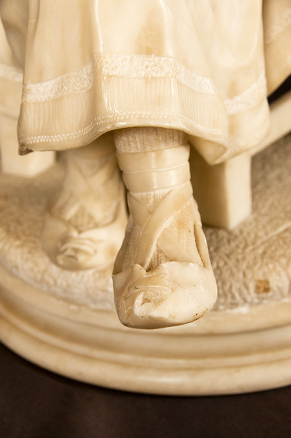 Alabaster sculpture of a seated girl with tambourine in traditional costume France 19th Century