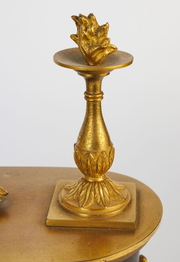 An Empire clock with a reading putti