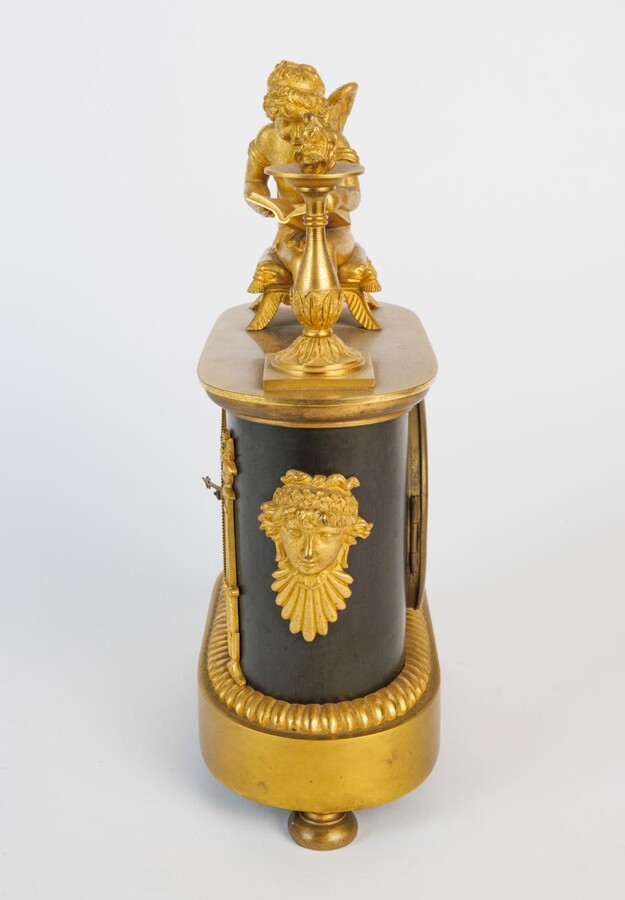 An Empire clock with a reading putti