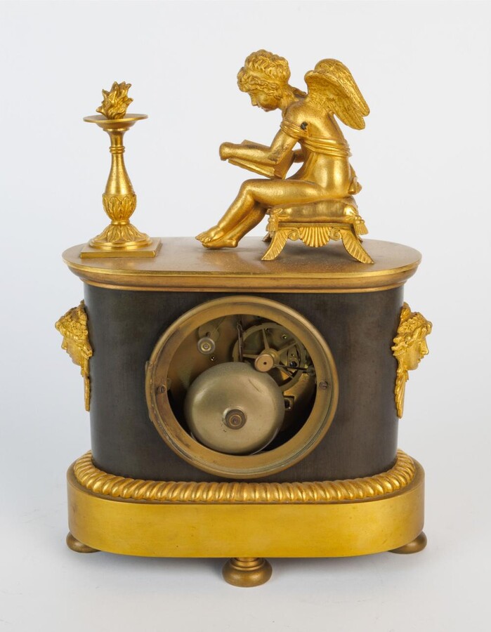 An Empire clock with a reading putti
